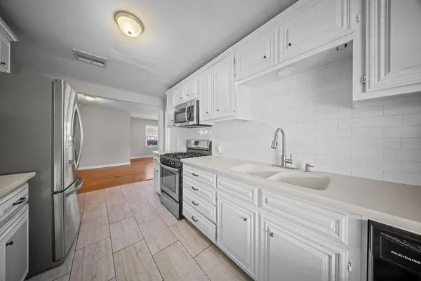a kitchen with granite countertop a sink stainless steel appliances and cabinets