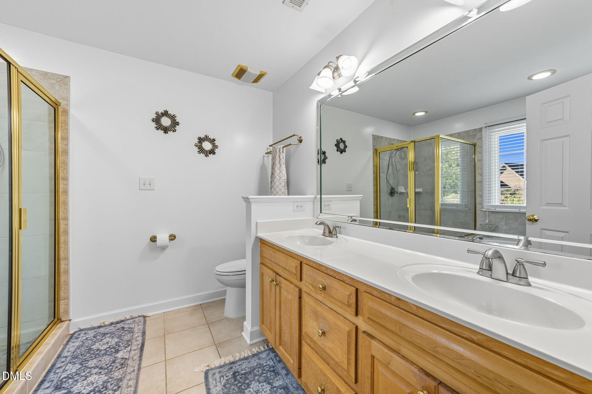 1617 Kendall Hill Road Willow Spring, NC 27592 - Photo 46 of 58 a spacious bathroom with double vanity a mirror and a shower