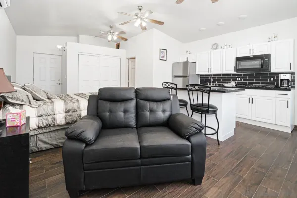 a living room with furniture kitchen view and a chandelier