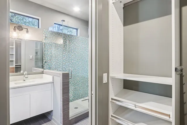 a bathroom with a double vanity sink mirror and shower