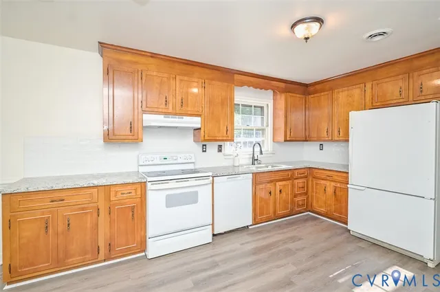 a kitchen with granite countertop wooden floors and white stainless steel appliances