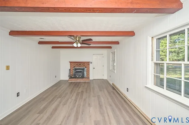 a view of a livingroom with wooden floor and a fireplace