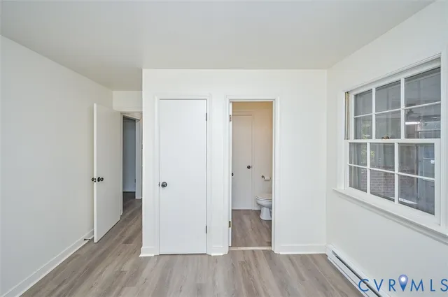 a view of empty room with wooden floor and window
