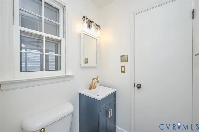 a bathroom with a toilet a sink and a mirror