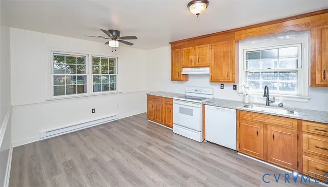 a kitchen with stainless steel appliances granite countertop a sink cabinets and wooden floor