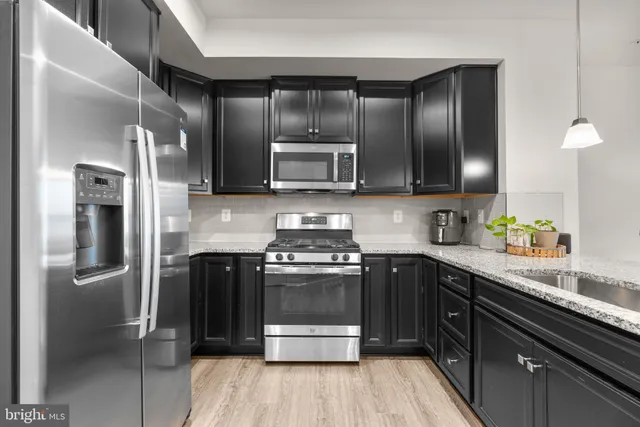 a kitchen with granite countertop stainless steel appliances and wooden cabinets