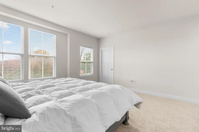 a large bed sitting in a bedroom next to a window