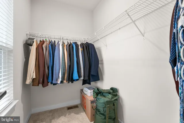 a view of walk in closet with clothes