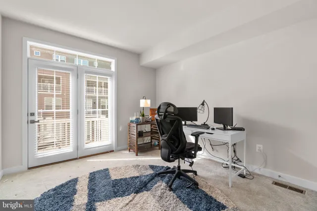 a view of a workspace with furniture and a window