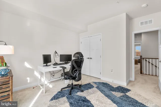 a view of a workspace with furniture and a window