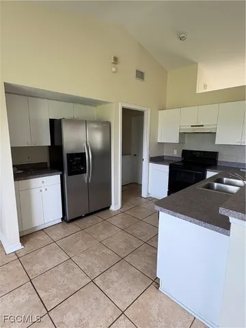 a kitchen with stainless steel appliances a sink a stove a microwave a sink a refrigerator and cabinets