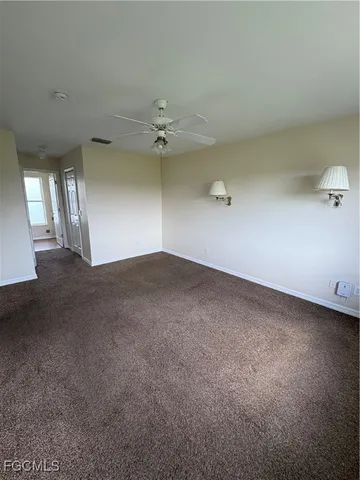 an empty room with a ceiling fan and fan