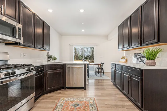 a kitchen with stainless steel appliances granite countertop lots of counter top space a sink and stove