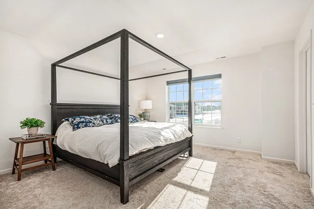 a bed sitting in a bedroom next to a window