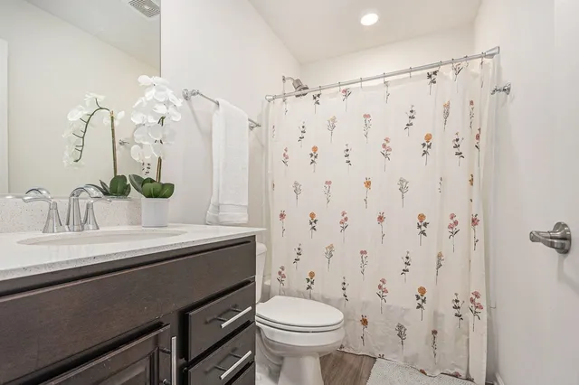 a bathroom with a sink a toilet and a mirror