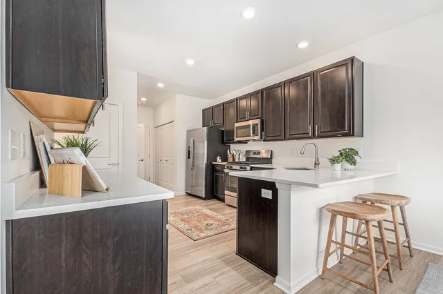 a kitchen with stainless steel appliances kitchen island granite countertop a refrigerator and a stove top oven