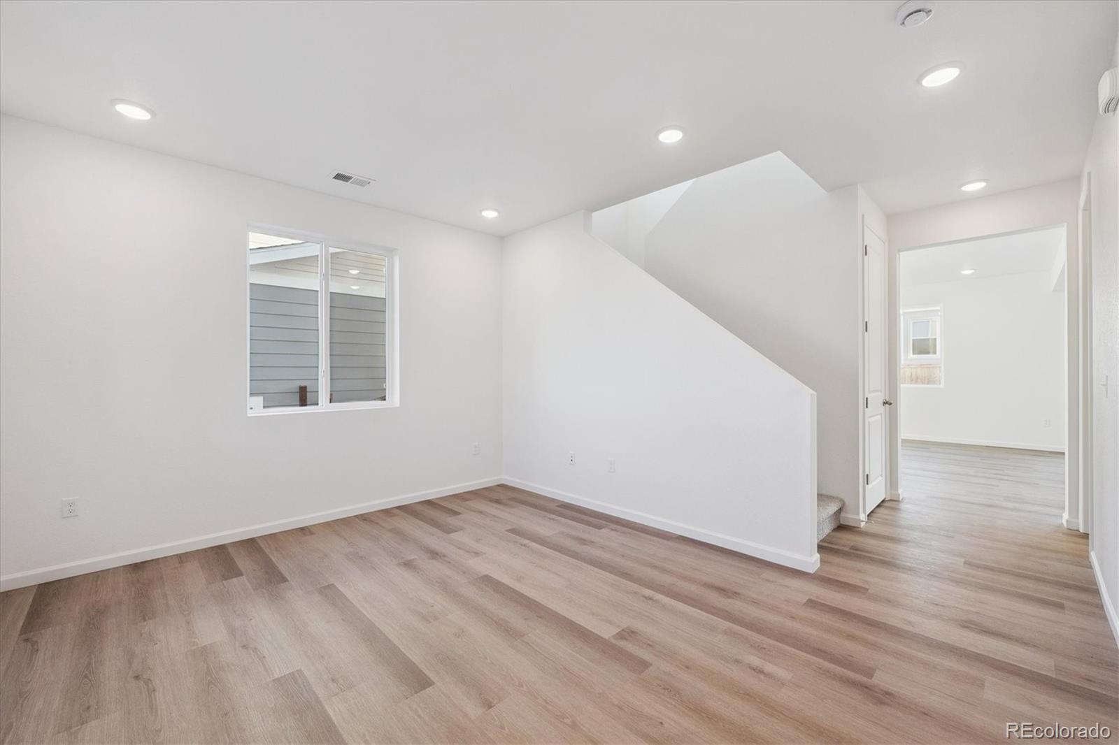 5594 Brangus Drive Windsor, CO 80528 - Photo 4 of 22 an empty room with wooden floor and windows