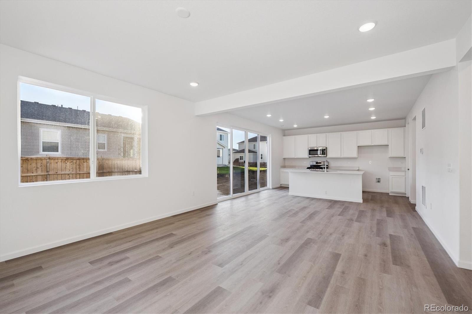 5594 Brangus Drive Windsor, CO 80528 - Photo 7 of 22 a view of a kitchen with wooden floor and windows