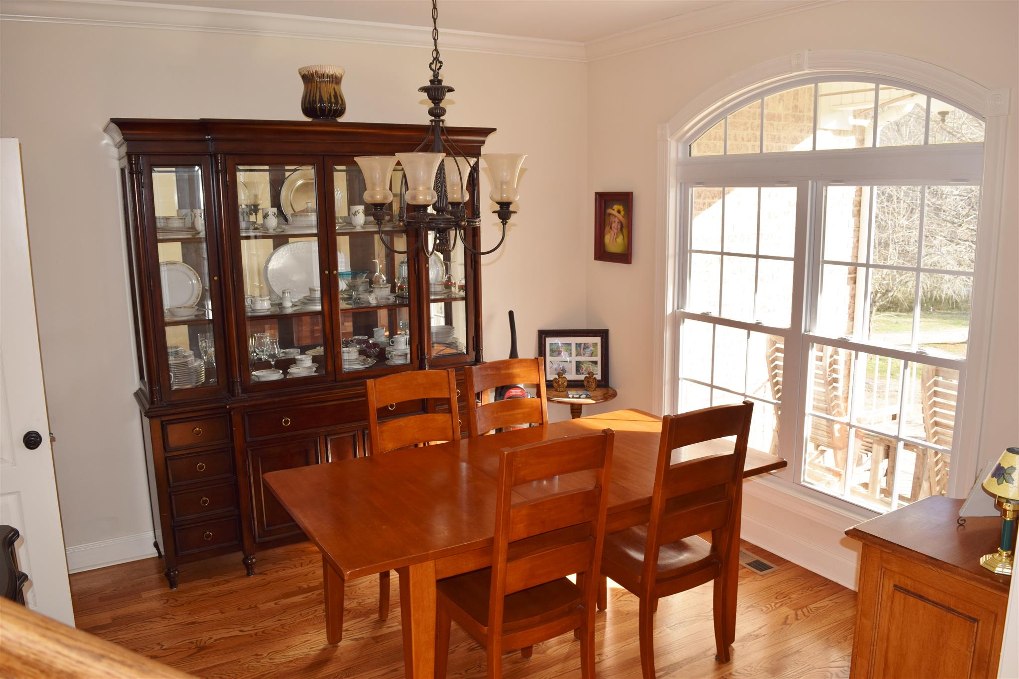 7418 Liberty Road Fairview, TN 37062 - Photo 3 of 18 a dining room with furniture a chandelier and wooden floor