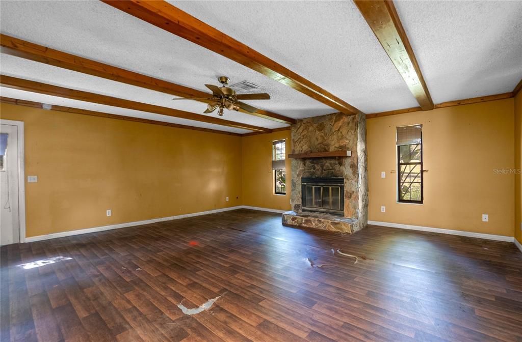 4893 South Old Floral City Road Inverness, FL 34450 - Photo 13 of 31 a view of a livingroom with wooden floor a ceiling fan and staircase
