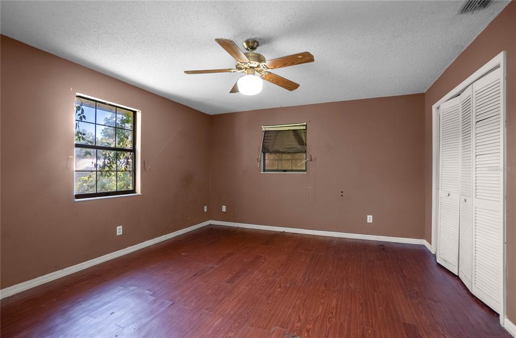 4893 South Old Floral City Road Inverness, FL 34450 - Photo 16 of 31 an empty room with wooden floor ceiling fan and windows