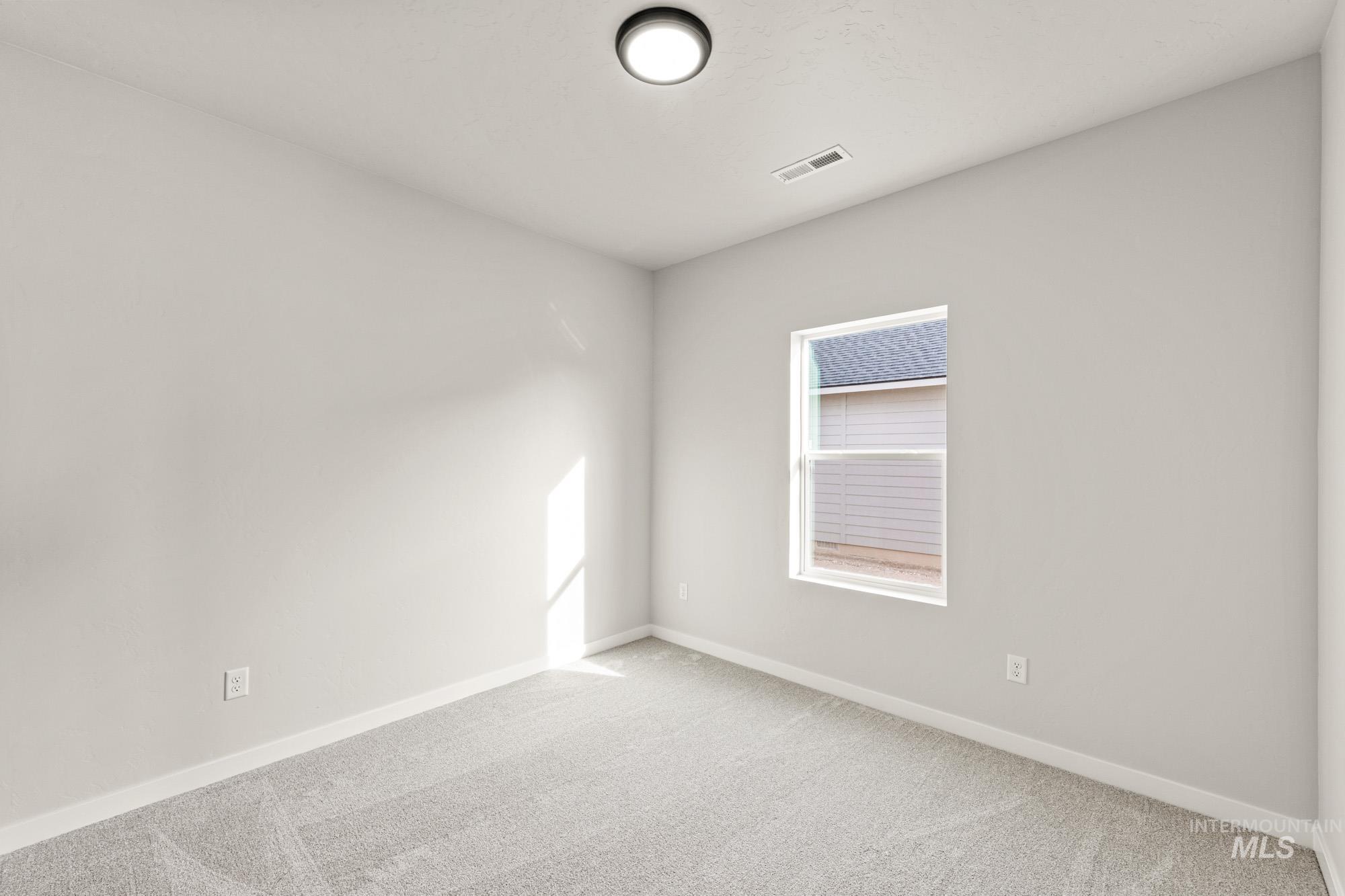 12865 Decatur Street Nampa, ID 83651 - Photo 13 of 20 Bright room featuring neutral-toned walls, light gray carpet, and white trim