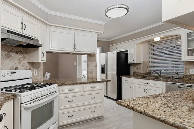 a kitchen with stainless steel appliances granite countertop a stove and a sink