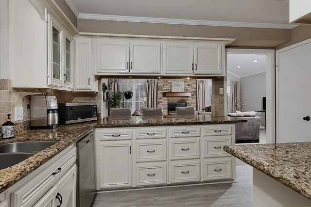 a kitchen with granite countertop a sink a stove and cabinets