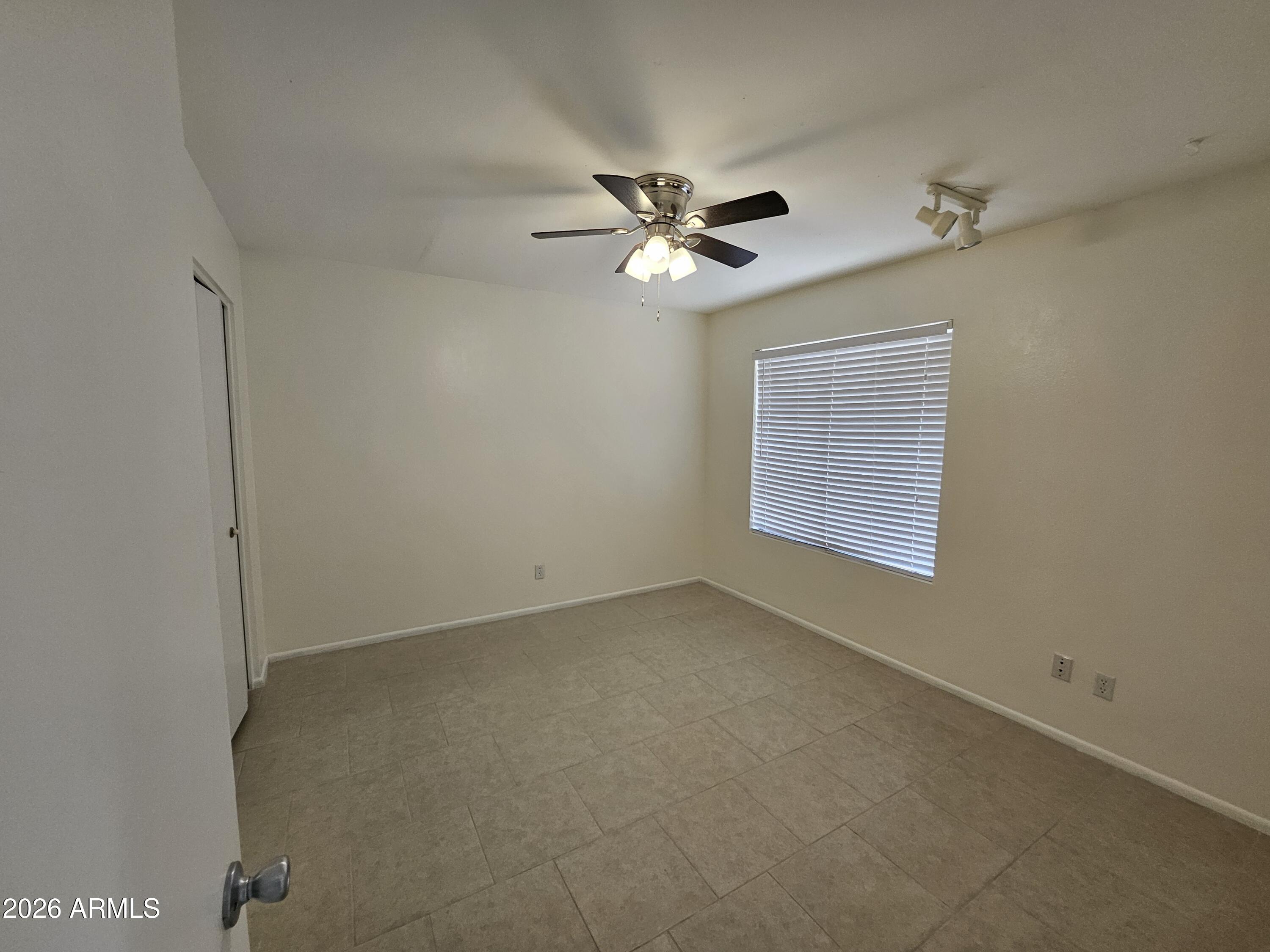 7038 South 42nd Street Phoenix, AZ 85042 - Photo 12 of 22 an empty room with a window and a ceiling fan