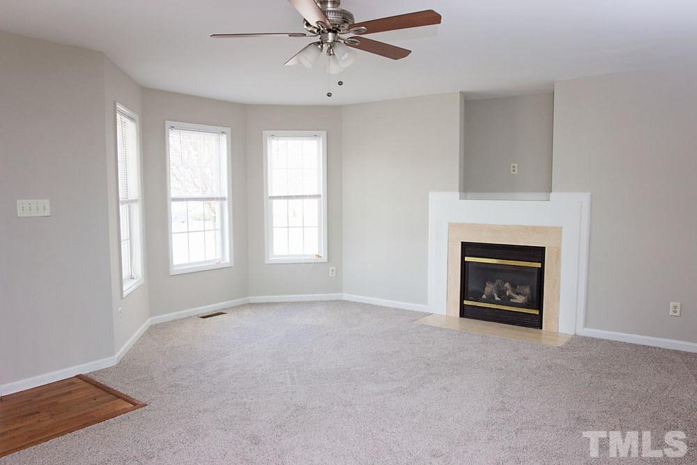 4308 Windstorm Way Raleigh, NC 27616 - Photo 6 of 16 a view of an empty room with a window and a fireplace