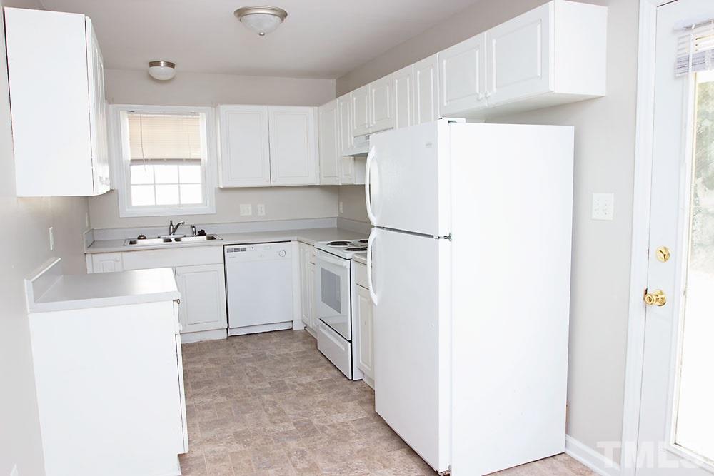 4308 Windstorm Way Raleigh, NC 27616 - Photo 7 of 16 a kitchen with a sink a refrigerator and white cabinets