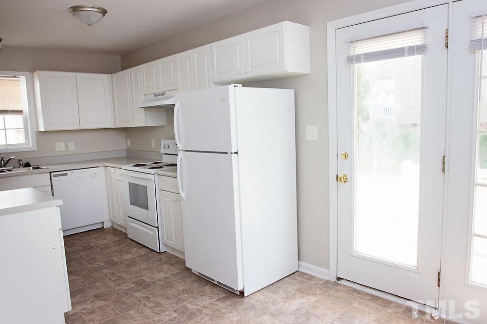 4308 Windstorm Way Raleigh, NC 27616 - Photo 8 of 16 a kitchen with white cabinets and white appliances