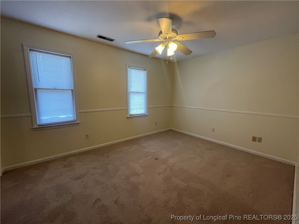 2059 Trexler Court Raleigh, NC 27606 - Photo 11 of 16 en empty room with windows and chandelier fan