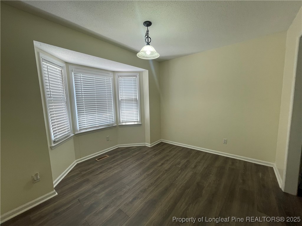 2059 Trexler Court Raleigh, NC 27606 - Photo 3 of 16 an empty room with wooden floor and windows