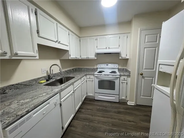 a kitchen with granite countertop stainless steel appliances a sink stove and refrigerator
