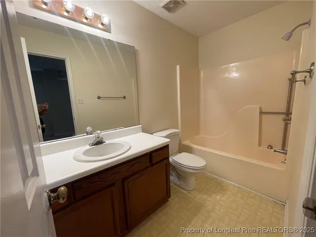 a bathroom with a granite countertop sink toilet a mirror and shower