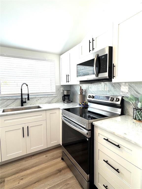 6980 Poinsetta Avenue Longboat Key, FL 34228 - Photo 12 of 18 a kitchen with stainless steel appliances a sink a stove and microwave