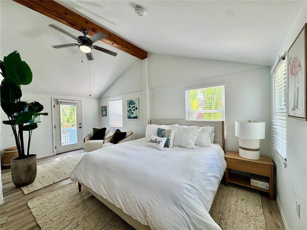 6980 Poinsetta Avenue Longboat Key, FL 34228 - Photo 4 of 18 a bedroom with a bed a couch and a potted plant