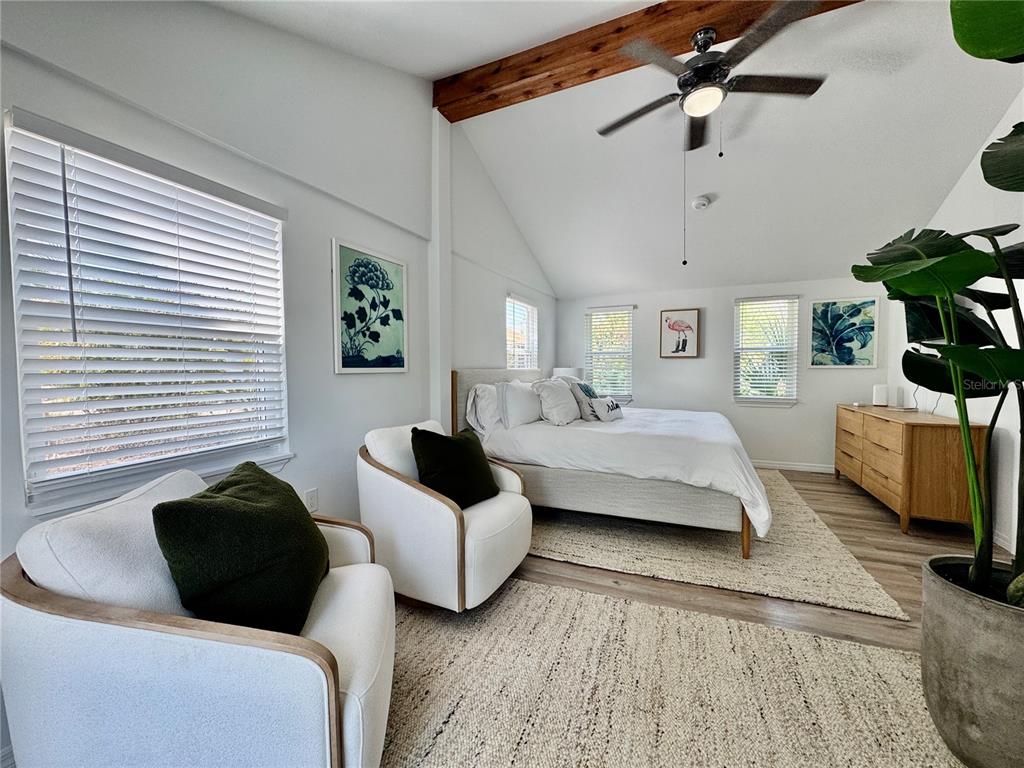 6980 Poinsetta Avenue Longboat Key, FL 34228 - Photo 5 of 18 a bedroom with a bed a couch and a chandelier