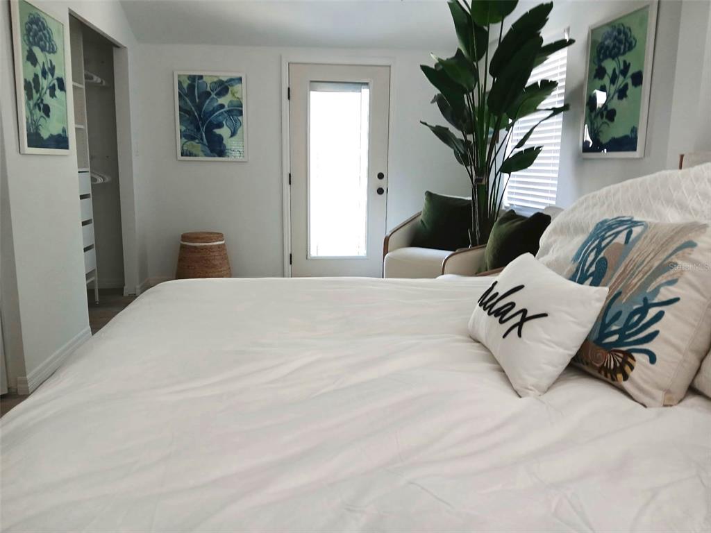 6980 Poinsetta Avenue Longboat Key, FL 34228 - Photo 6 of 18 a bedroom with a large bed and a potted plant