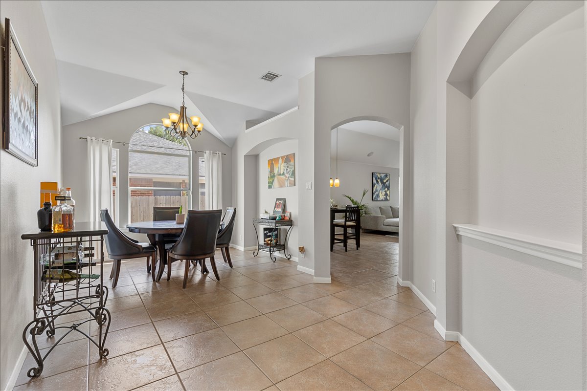 9012 Meacham Way Austin, TX 78749 - Photo 6 of 34 Spacious interior featuring neutral paint, tile flooring, arched doorways, vaulted ceilings, and an arched window