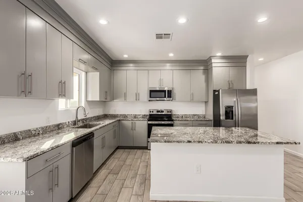 a kitchen with stainless steel appliances granite countertop a sink stove and microwave