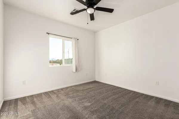 an empty room with chandelier fan