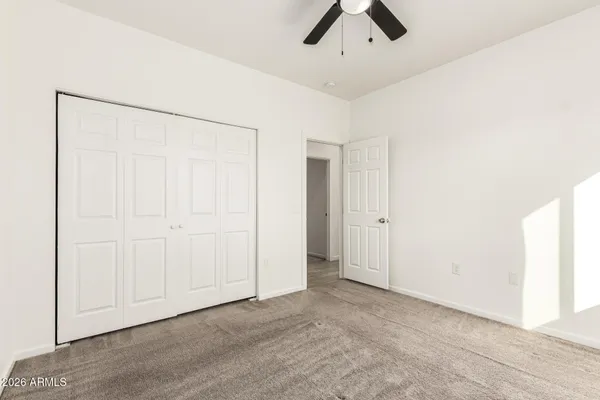 an empty room with a window and ceiling fan