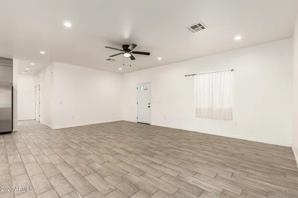 wooden floor in an empty room with a kitchen