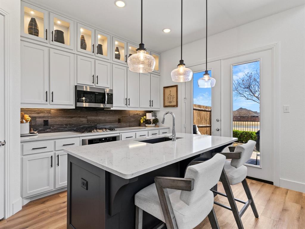 a kitchen with cabinets a center island a dining table and chairs
