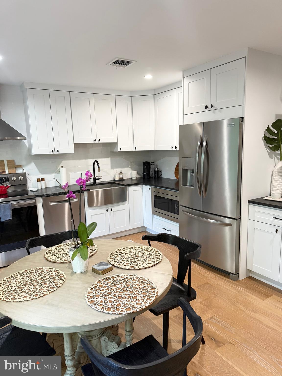 411 Conestoga Road, Unit 22 Devon, PA 19333 - Photo 7 of 14 a kitchen with stainless steel appliances kitchen island granite countertop a dining table and chairs