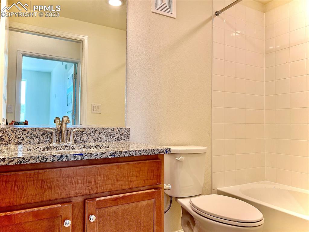 3865 Presidio Point, Unit 202 Colorado Springs, CO 80920 - Photo 21 of 30 a bathroom with a granite countertop sink toilet and shower