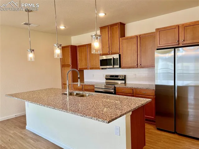 a kitchen with stainless steel appliances granite countertop a sink stove and refrigerator