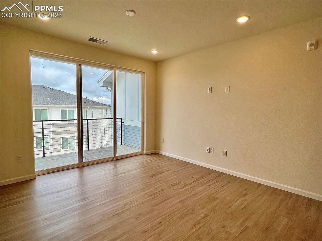 3865 Presidio Point, Unit 202 Colorado Springs, CO 80920 - Photo 7 of 30 wooden floor in an empty room with a window